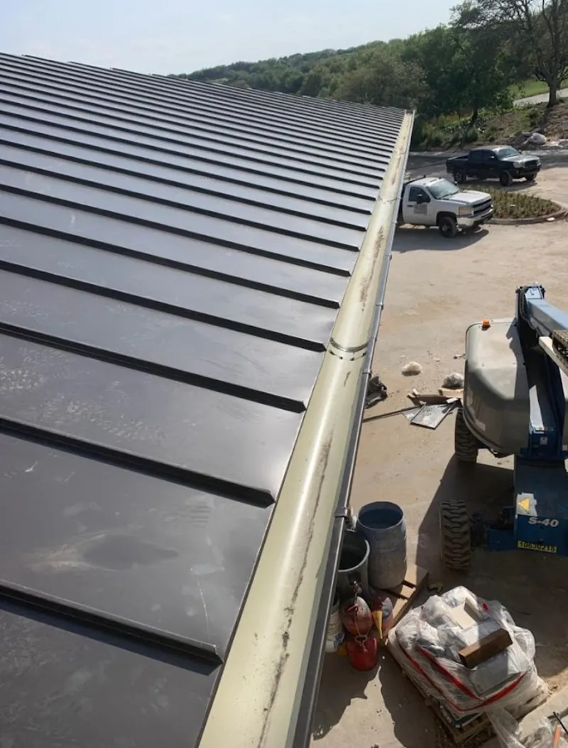 Standing seam panel and gutter detail on a metal roofing jobsite in Carlisle